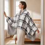 Poncho plaid à carreaux blancs porté par une femme debout de profil, dans l'encadrement d'une porte de chambre.