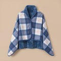 Poncho plaid à carreaux bleus et blancs, présenté à plat sur un fond uni pour montrer son design.