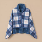 Poncho plaid à carreaux bleus et blancs, présenté à plat sur un fond uni pour montrer son design.