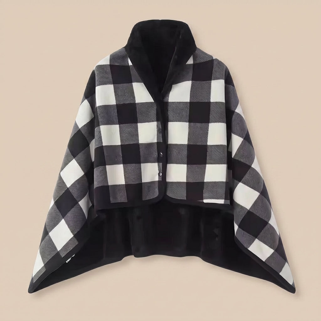 Poncho plaid à carreaux noir et blanc, présenté à plat sur un fond uni clair, vue de face.