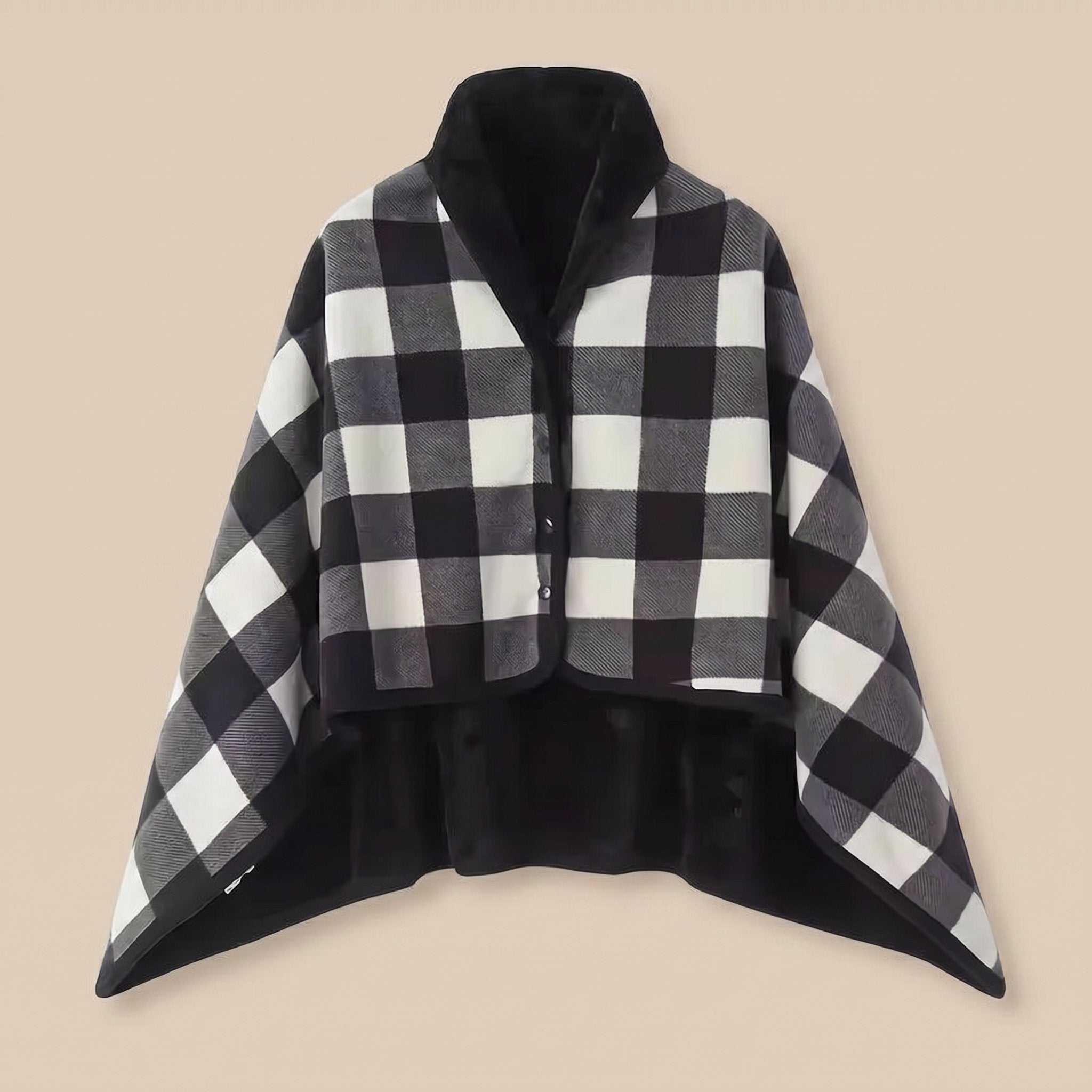 Poncho plaid à carreaux noir et blanc, présenté à plat sur un fond uni clair, vue de face.