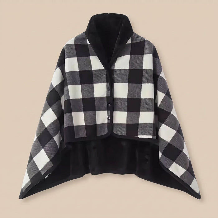Poncho plaid à carreaux noir et blanc, présenté à plat sur un fond uni clair, vue de face.