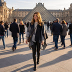 Poncho plaid colorblock gris porté par une femme souriante marchant dans une grande cour.
