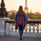 Poncho plaid à capuche motif floral, porté par une femme de dos marchant sur un pont au coucher du soleil.
