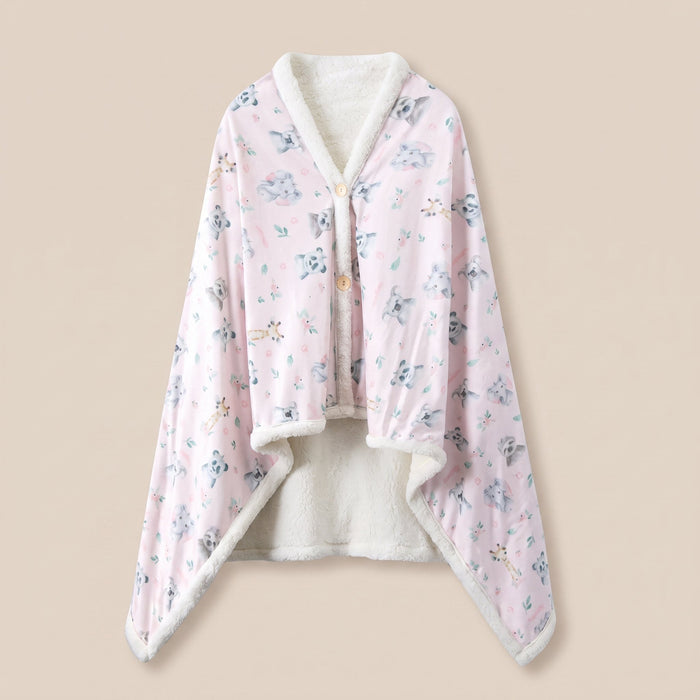 Poncho plaid Koalas et fleurs, vue a plat sur fond creme, imprime koalas gris sur rose pale et doublure sherpa ecrue.