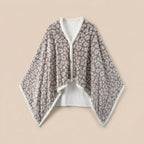 Poncho plaid motif léopard gris, présenté à plat sur un fond uni, montrant son design intégral.