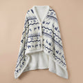 Poncho plaid motif nordique posé à plat, montrant son motif de cerfs et flocons.