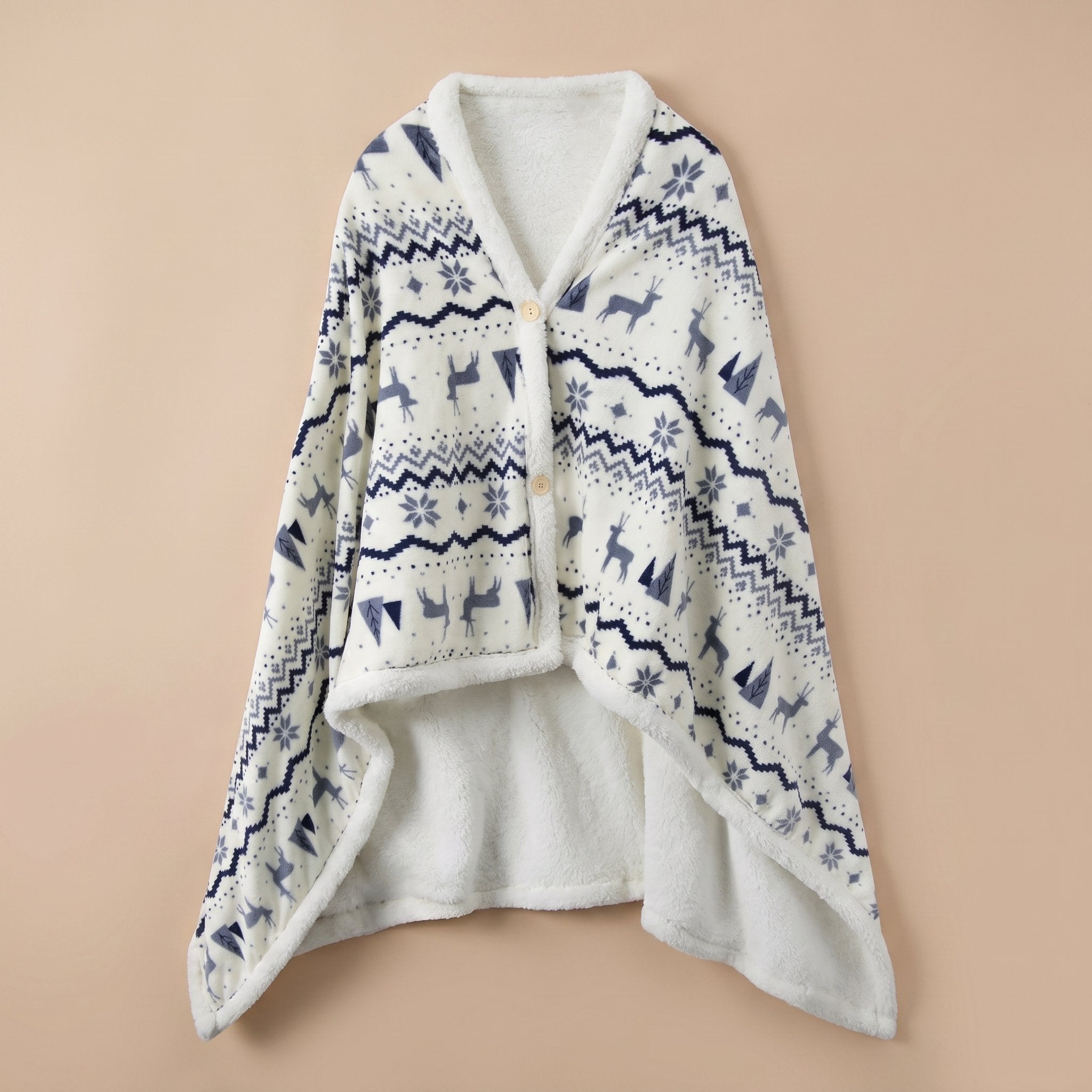 Poncho plaid motif nordique posé à plat, montrant son motif de cerfs et flocons.