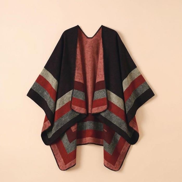 Poncho plaid à rayures rouges, noires et grises, posé à plat et vu de face sur fond uni.