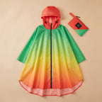 Poncho de pluie à capuche femme vert, jaune, orange et rouge, présenté à plat, déplié