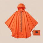 Poncho de pluie vélo à capuche orange déplié à plat, montrant sa forme complète et sa pochette de rangement assortie