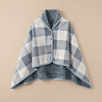 Poncho polaire à carreaux gris et blanc présenté à plat, révélant son intérieur doux et réversible.