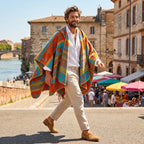 Poncho polaire à capuche motif ethnique orange et bleu, porté par un homme souriant marchant en extérieur.