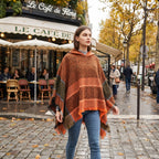 Poncho pull femme à capuche cuivre, porté par une femme marchant sur un trottoir pavé.