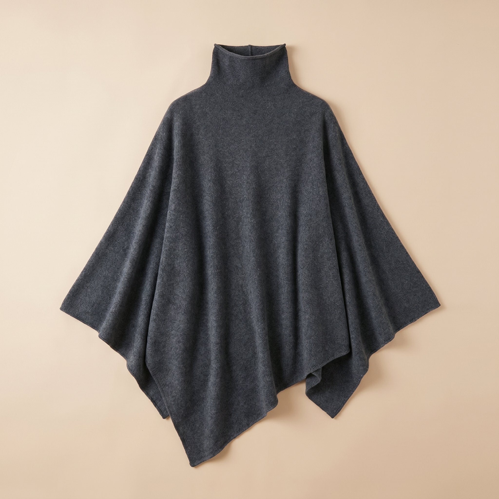 Poncho pull femme anthracite, col roulé, posé à plat sur un fond clair.