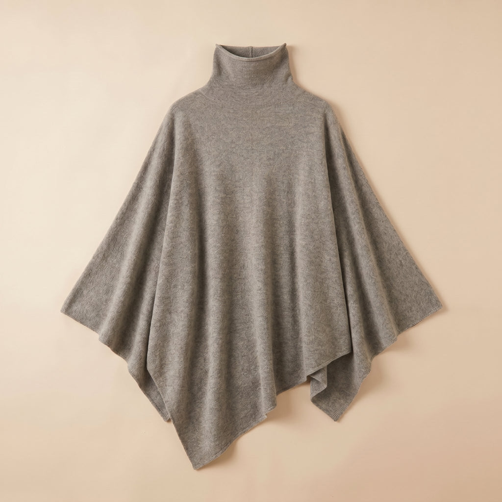 Poncho pull femme gris clair, col roulé, présenté à plat.