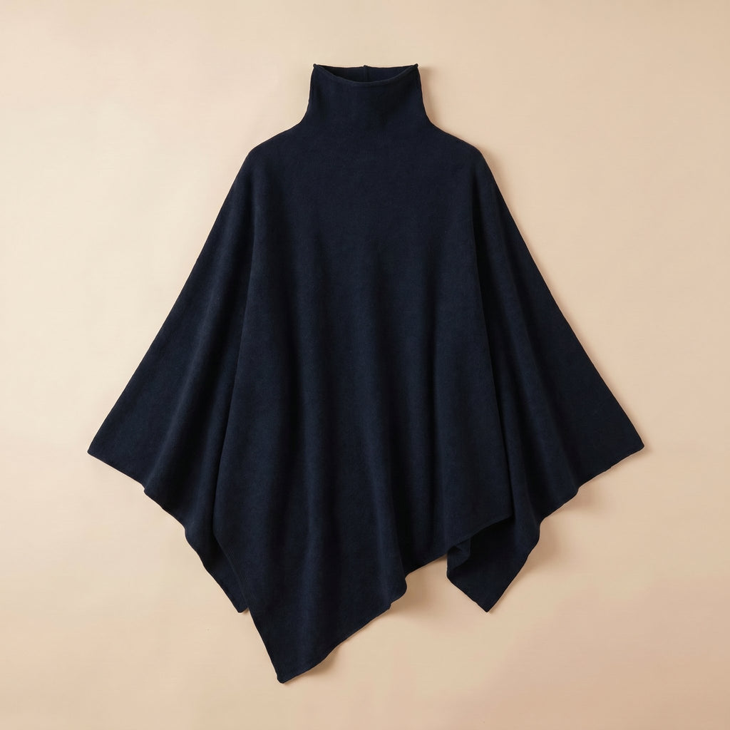 Poncho pull femme bleu marine, col roulé, étendu sur un fond clair.