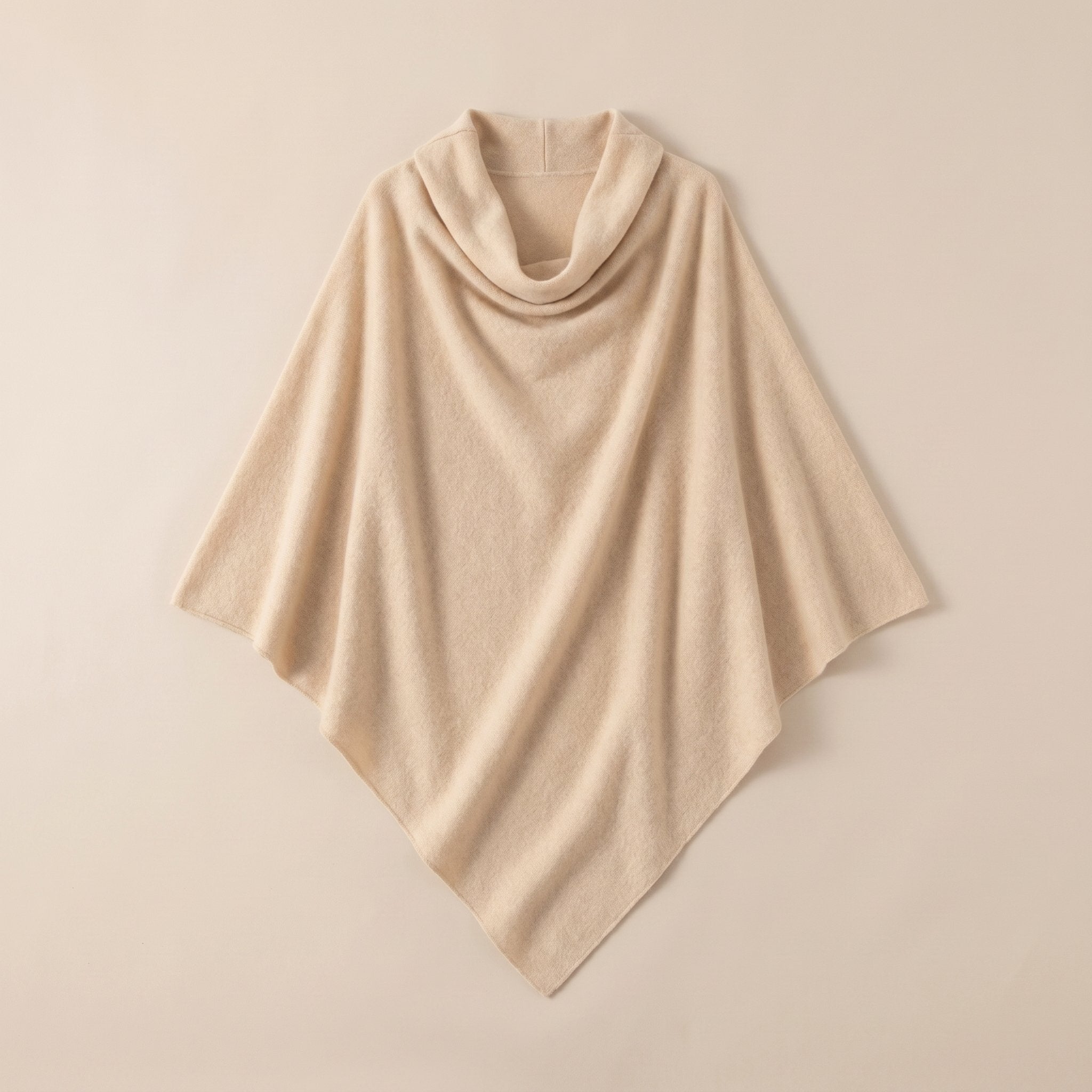 Poncho pull femme col roulé beige, présenté à plat sur un fond uni clair.