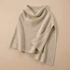Poncho pull femme couleur beige, présenté à plat, avec le col roulé bien visible.