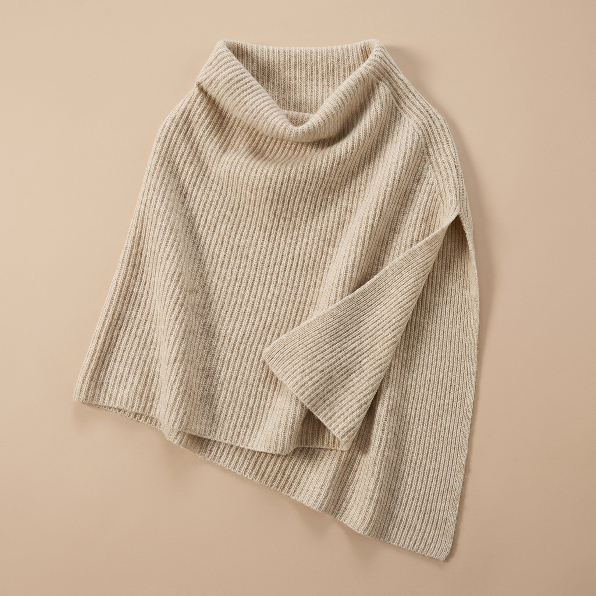 Poncho pull femme couleur beige, présenté à plat, avec le col roulé bien visible.