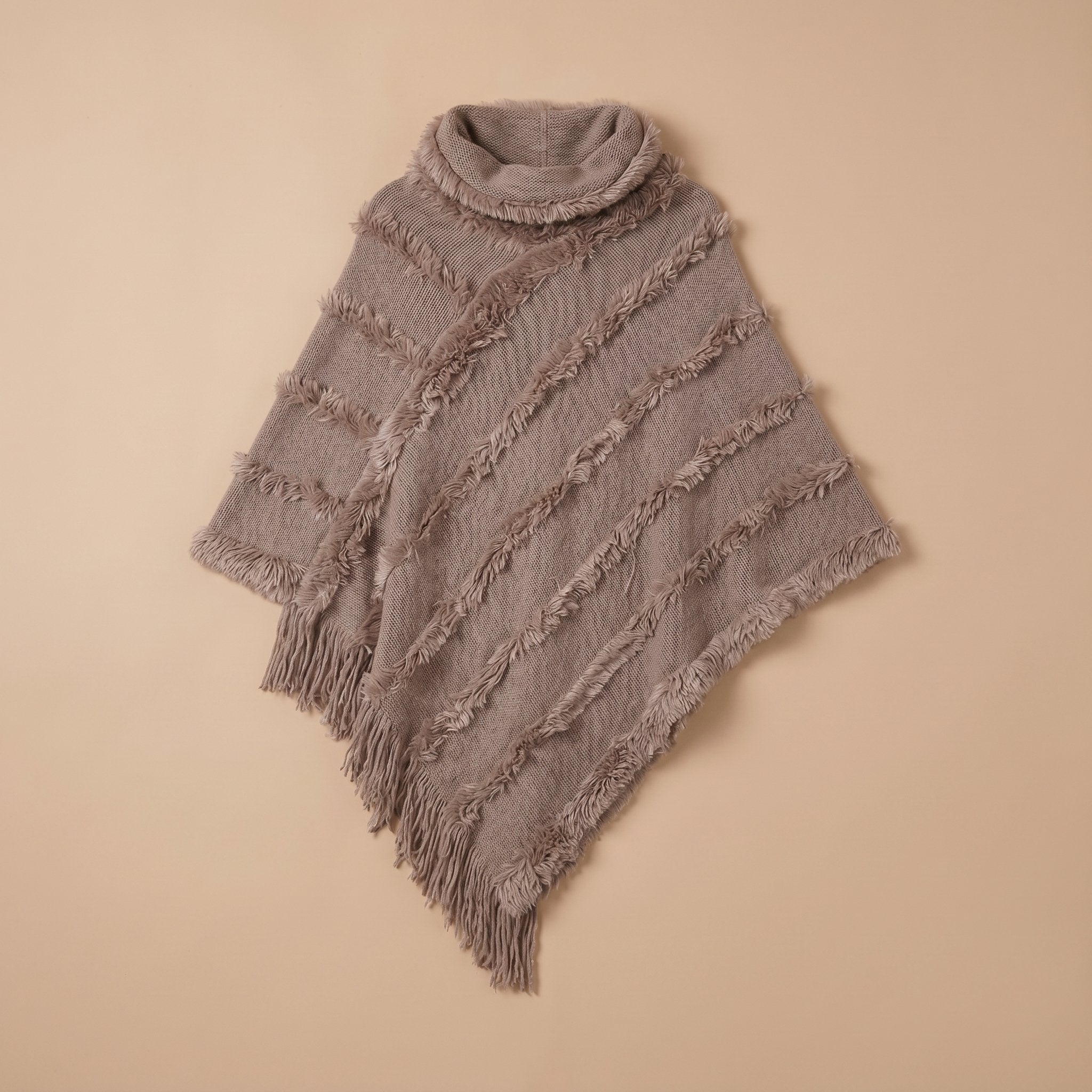 Poncho pull femme col roulé gris taupe, étalé à plat avec ses franges visibles.