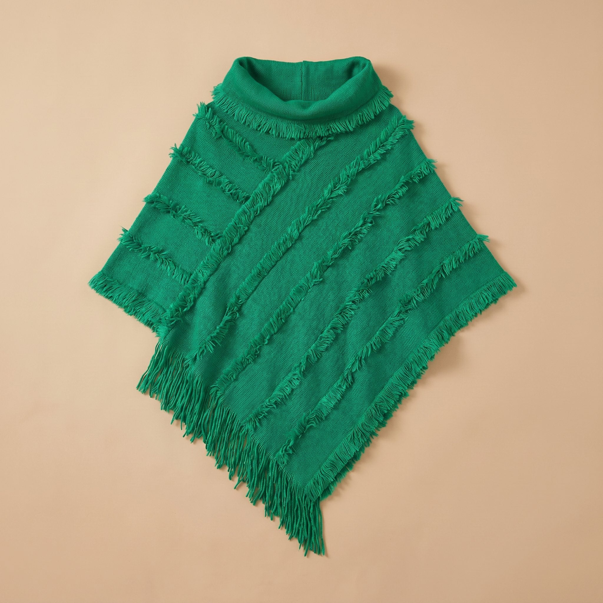 Poncho pull femme col roulé vert émeraude, posé à plat avec ses détails de franges.