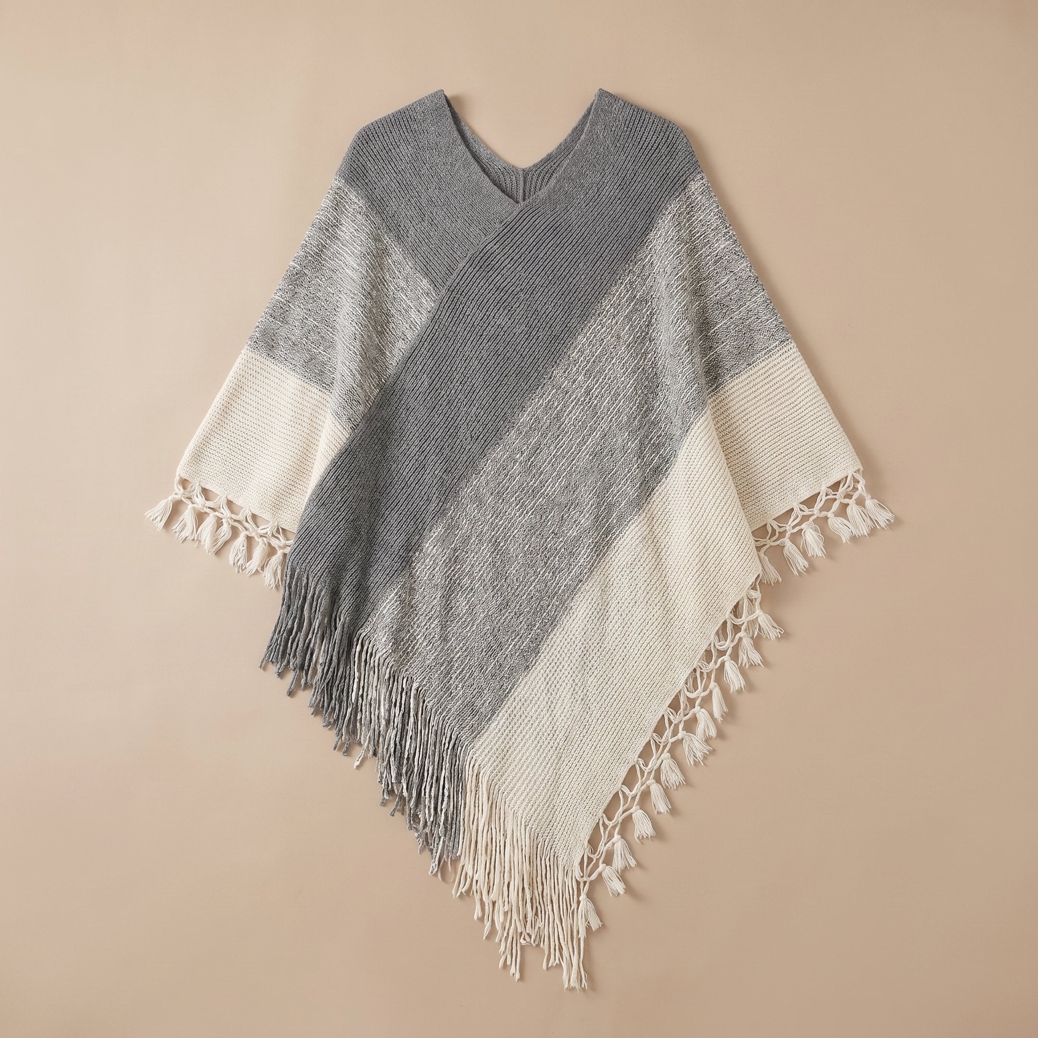 Poncho pull femme colorblock gris et blanc, étalé à plat sur un fond neutre.
