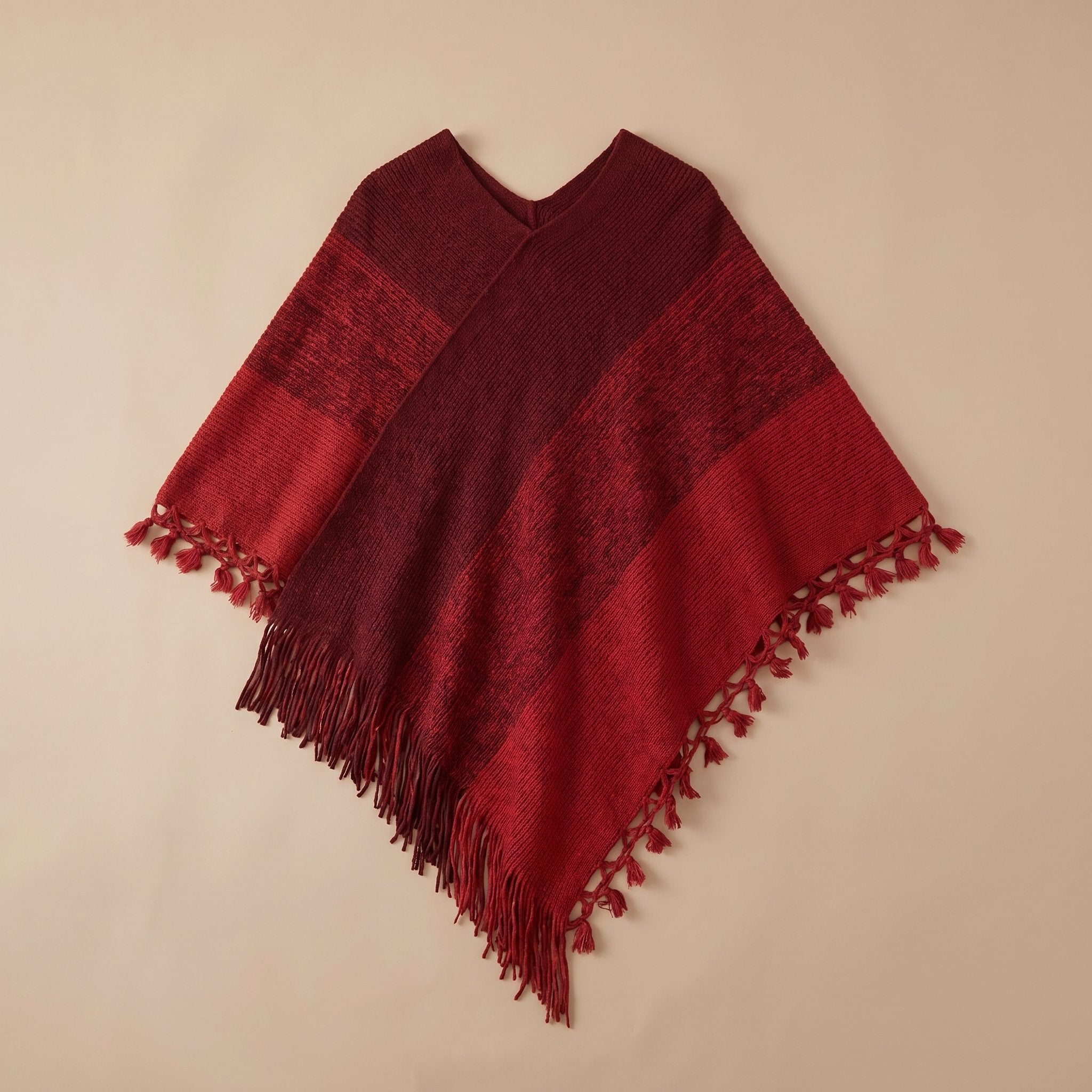 Poncho pull femme colorblock rouge et bordeaux, photographié à plat sur un fond clair.