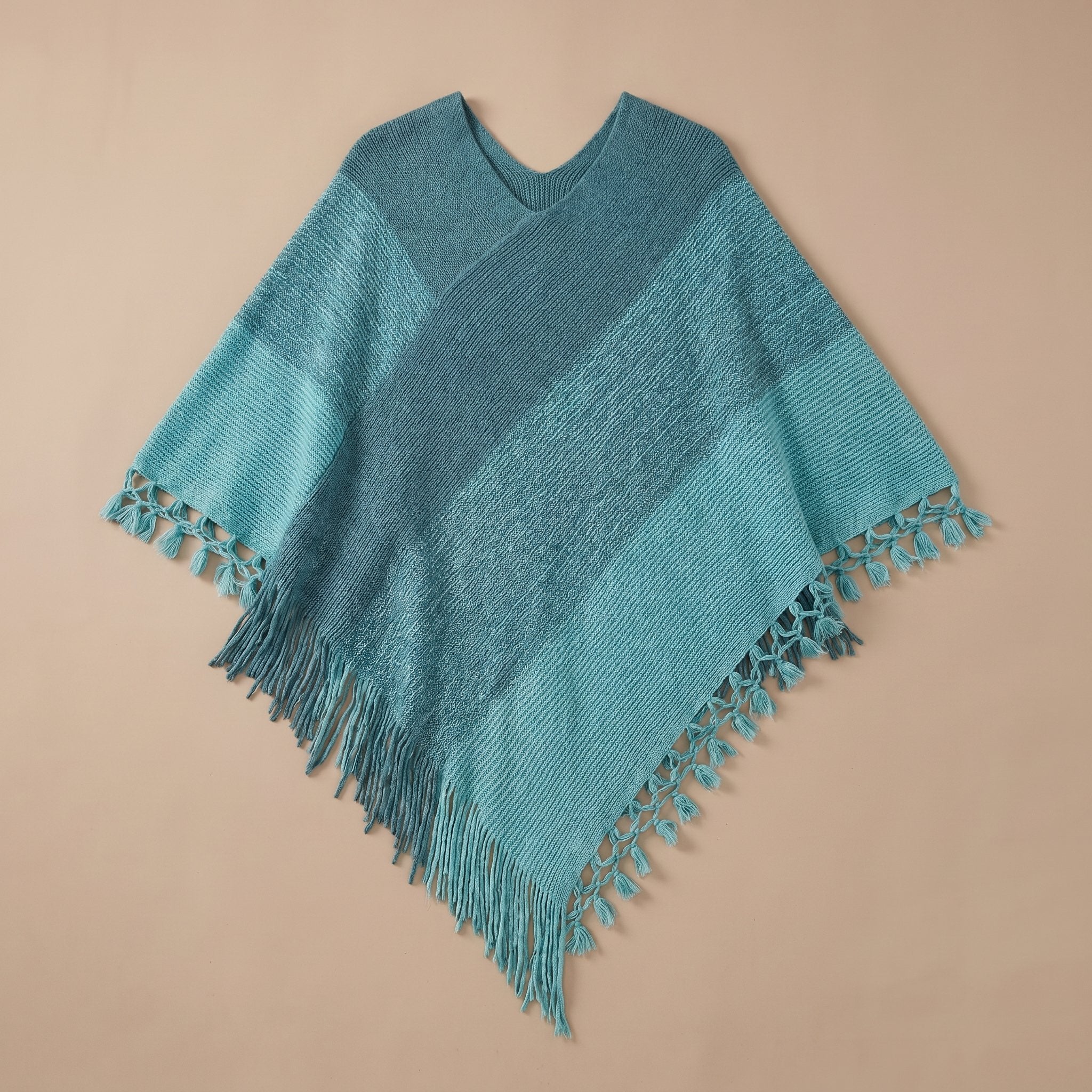 Poncho pull femme colorblock bleu et turquoise, présenté à plat avec ses franges.