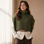 Poncho pull femme maille torsadée vert, porté par une femme en intérieur, vue de trois quarts.