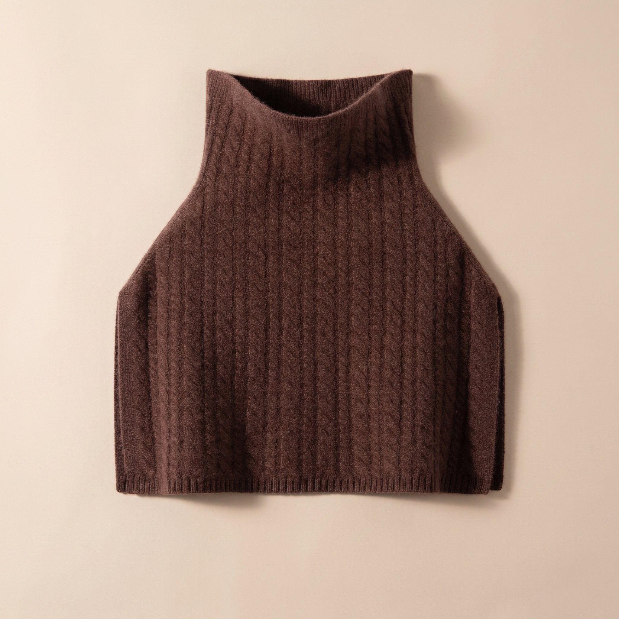 Poncho pull femme maille torsadée marron chocolat, posé à plat sur un fond uni.