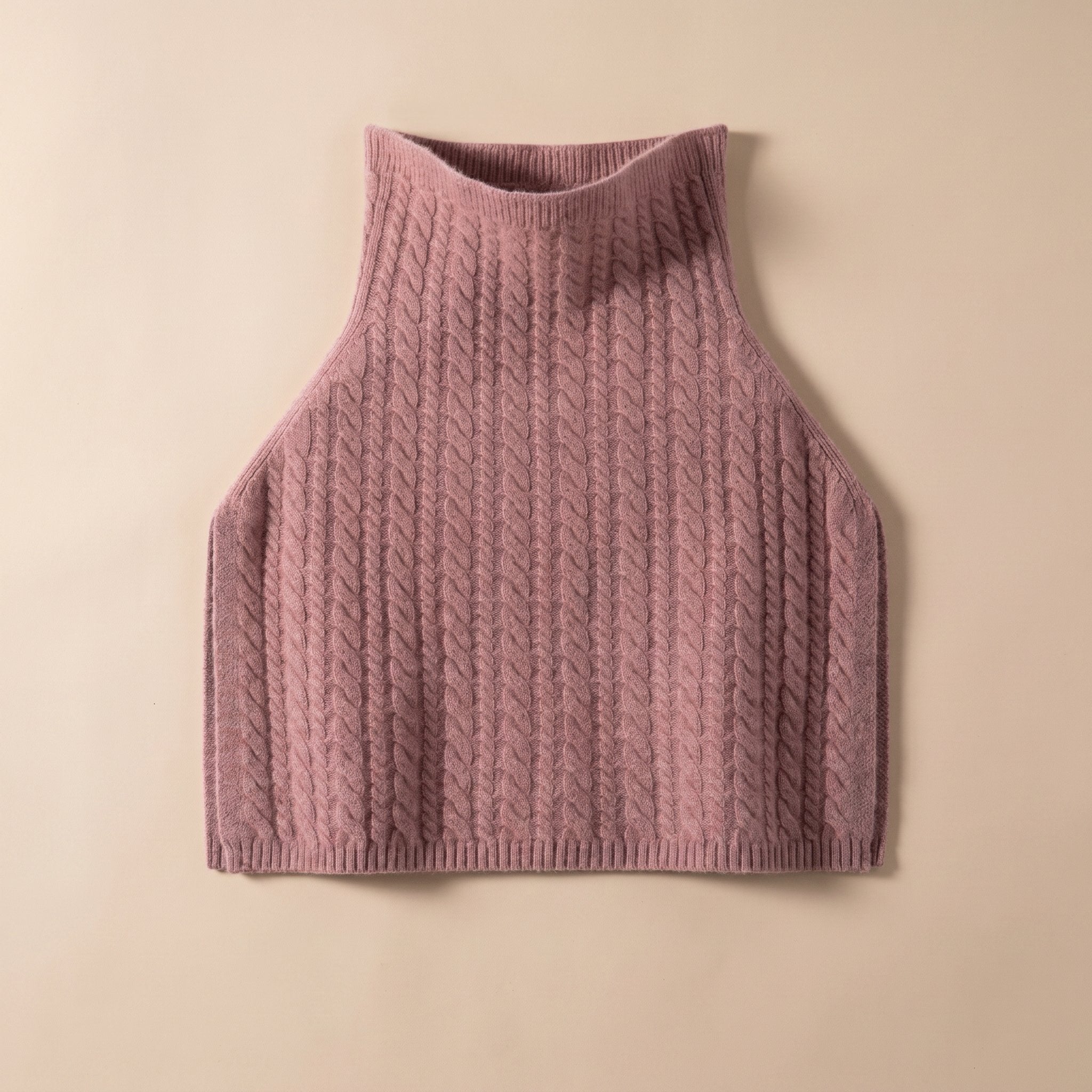Poncho pull femme maille torsadée rose poudré, présenté à plat sur un fond clair.