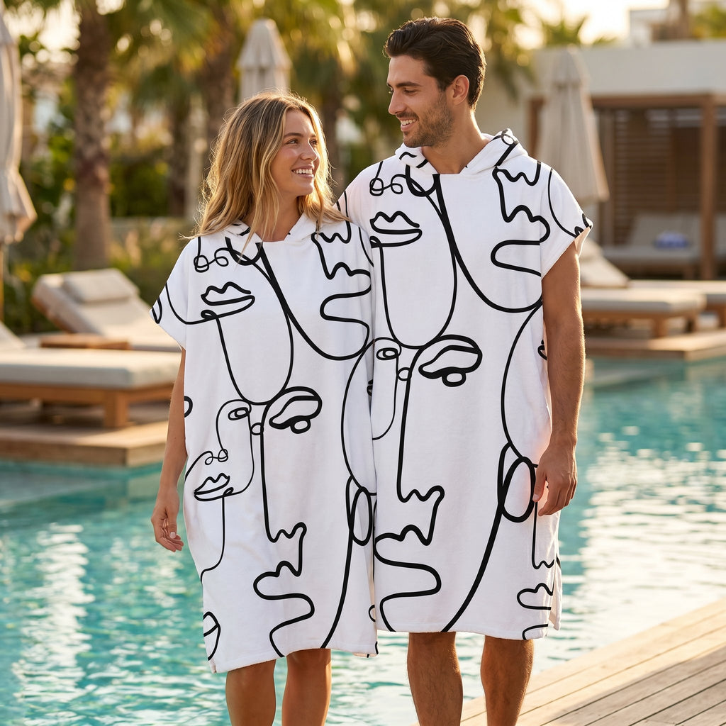 Poncho serviette à capuche adulte Visages au trait porté au bord de la piscine