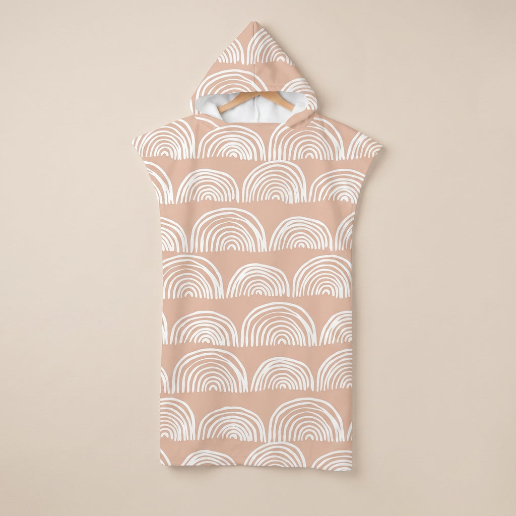 Poncho serviette a capuche motif Arches pêche, suspendu sur un cintre, vue de face.