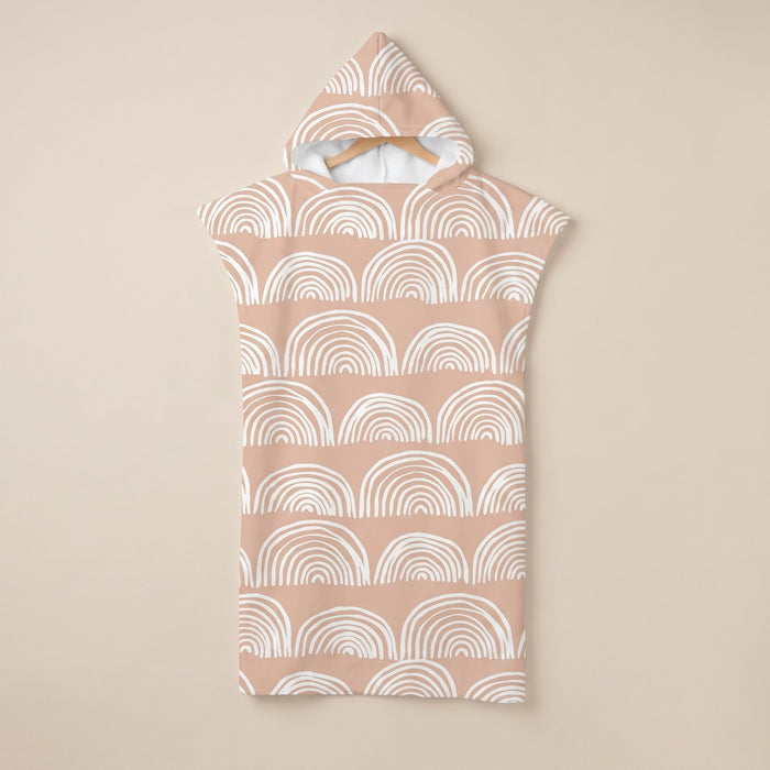 Poncho serviette a capuche motif Arches pêche, suspendu sur un cintre, vue de face.