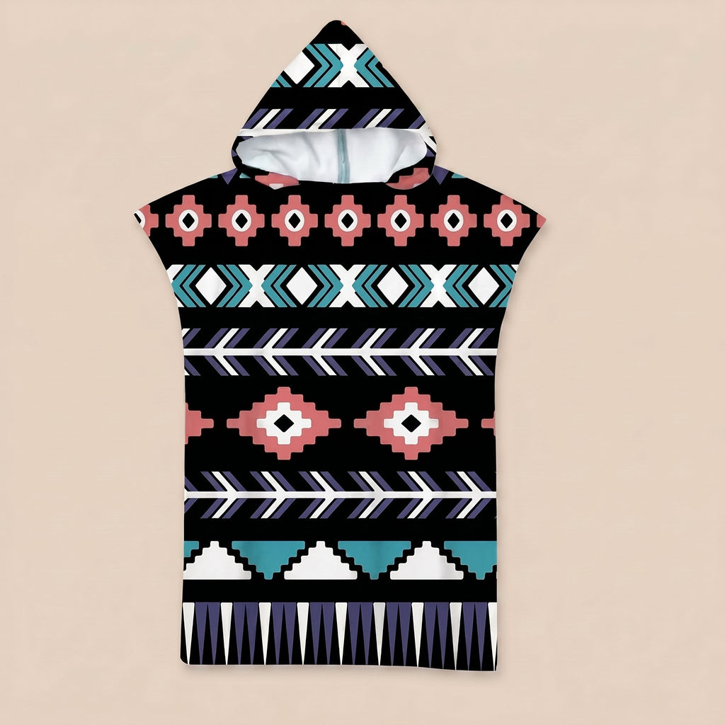 Poncho serviette a capuche motif aztèque rose et turquoise, posé à plat sur un fond uni.
