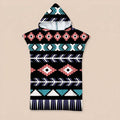 Poncho serviette a capuche motif aztèque rose et turquoise, posé à plat sur un fond uni.