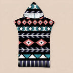 Poncho serviette a capuche motif aztèque rose et turquoise, posé à plat sur un fond uni.
