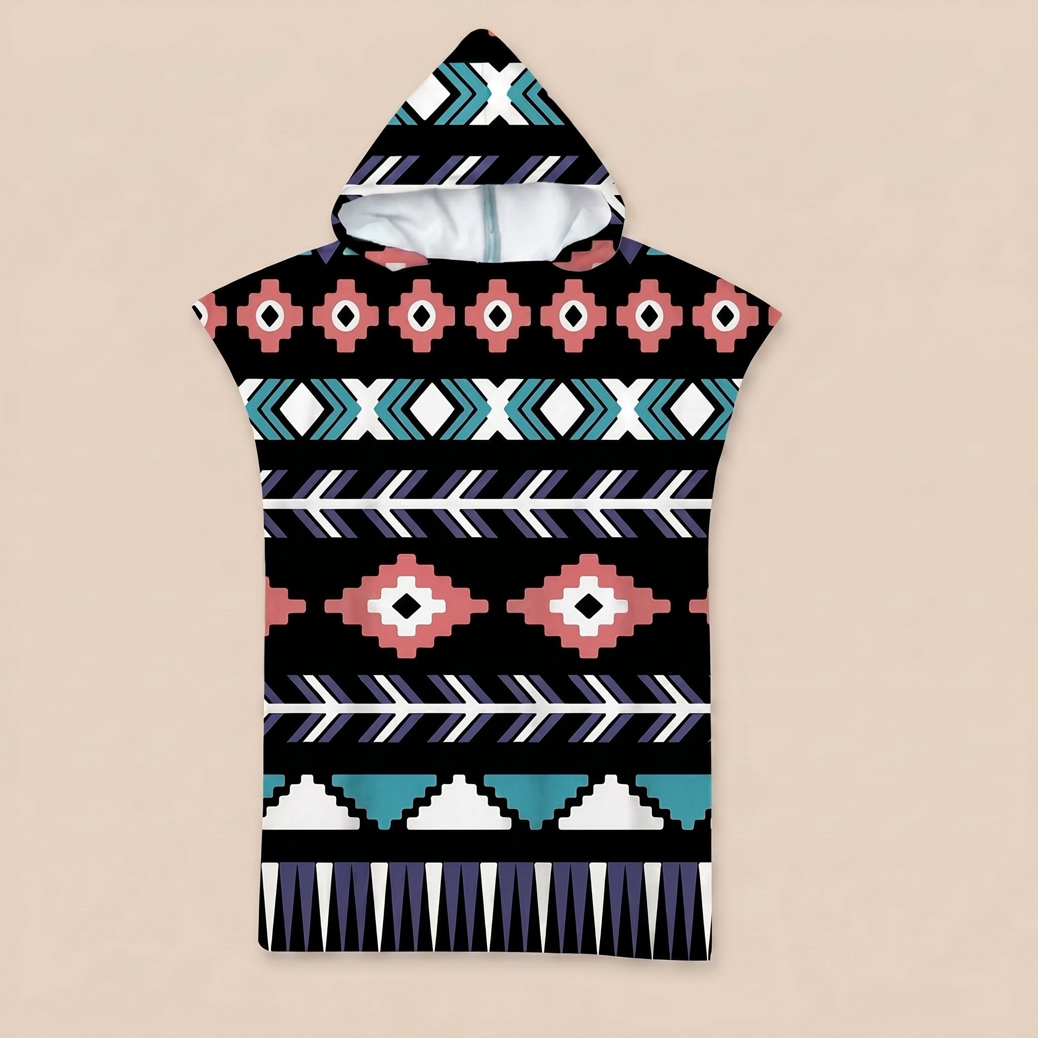 Poncho serviette a capuche motif aztèque rose et turquoise, posé à plat sur un fond uni.