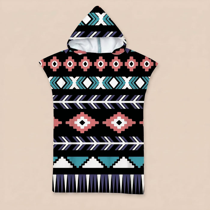 Poncho serviette a capuche motif aztèque rose et turquoise, posé à plat sur un fond uni.