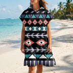 Poncho serviette a capuche motif aztèque rose et turquoise, porté par une femme, vue de face sur une plage ensoleillée.