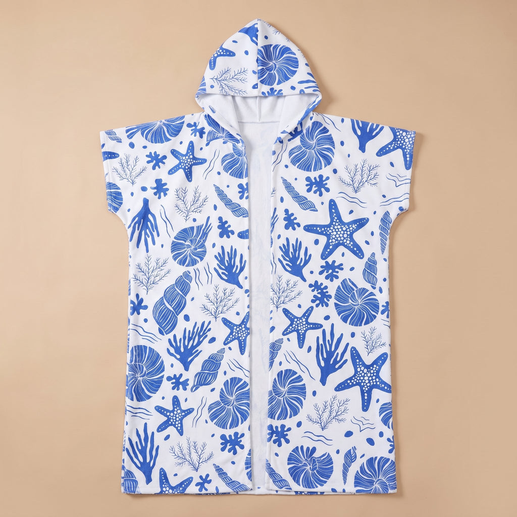 Poncho serviette à capuche motif coquillages bleus, posé à plat, vue de face sur fond uni.