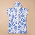 Poncho serviette à capuche motif coquillages bleus, posé à plat, vue de face sur fond uni.