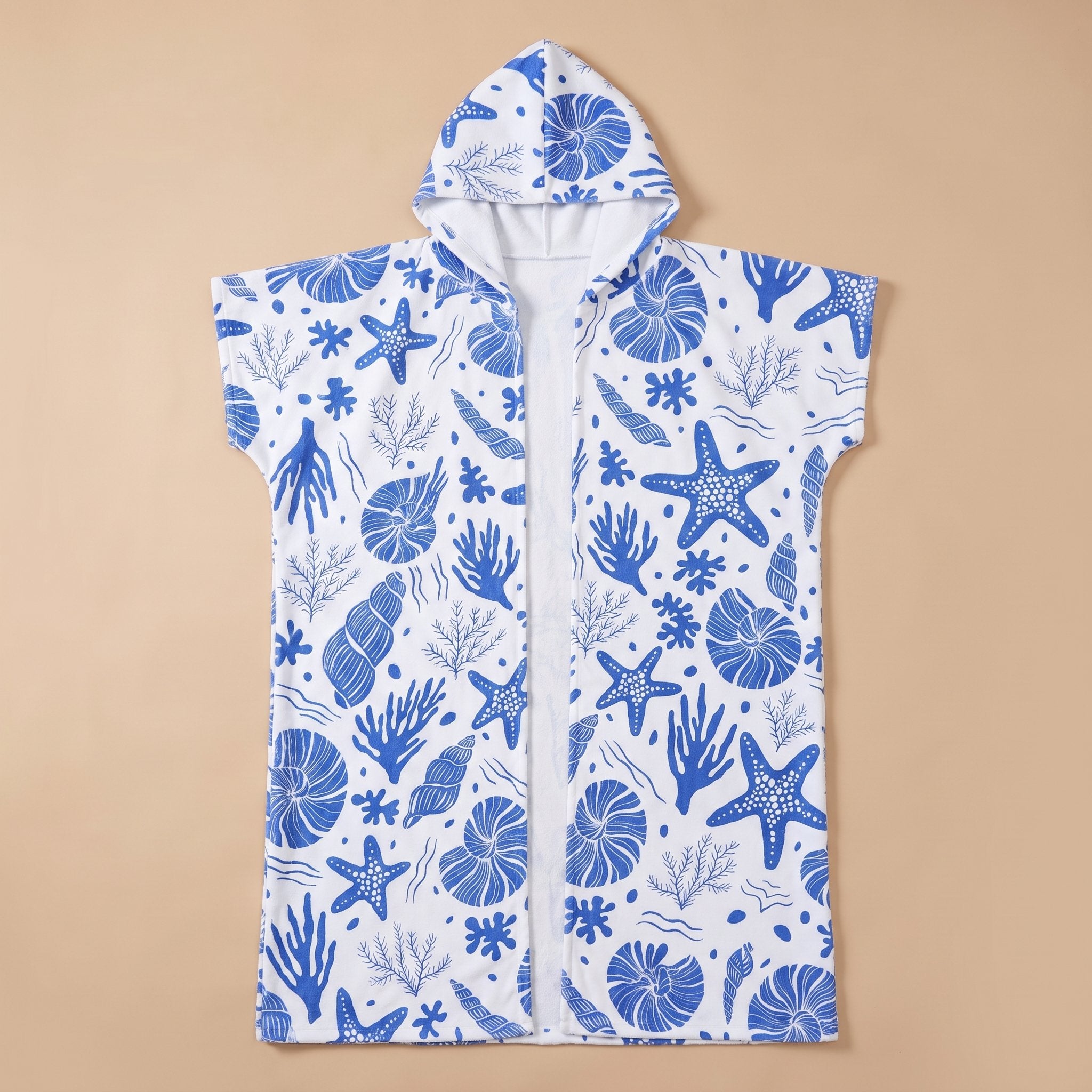 Poncho serviette à capuche motif coquillages bleus, posé à plat, vue de face sur fond uni.