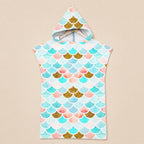 Poncho serviette a capuche motif écailles menthe et corail, présenté sur un cintre, vu de face.