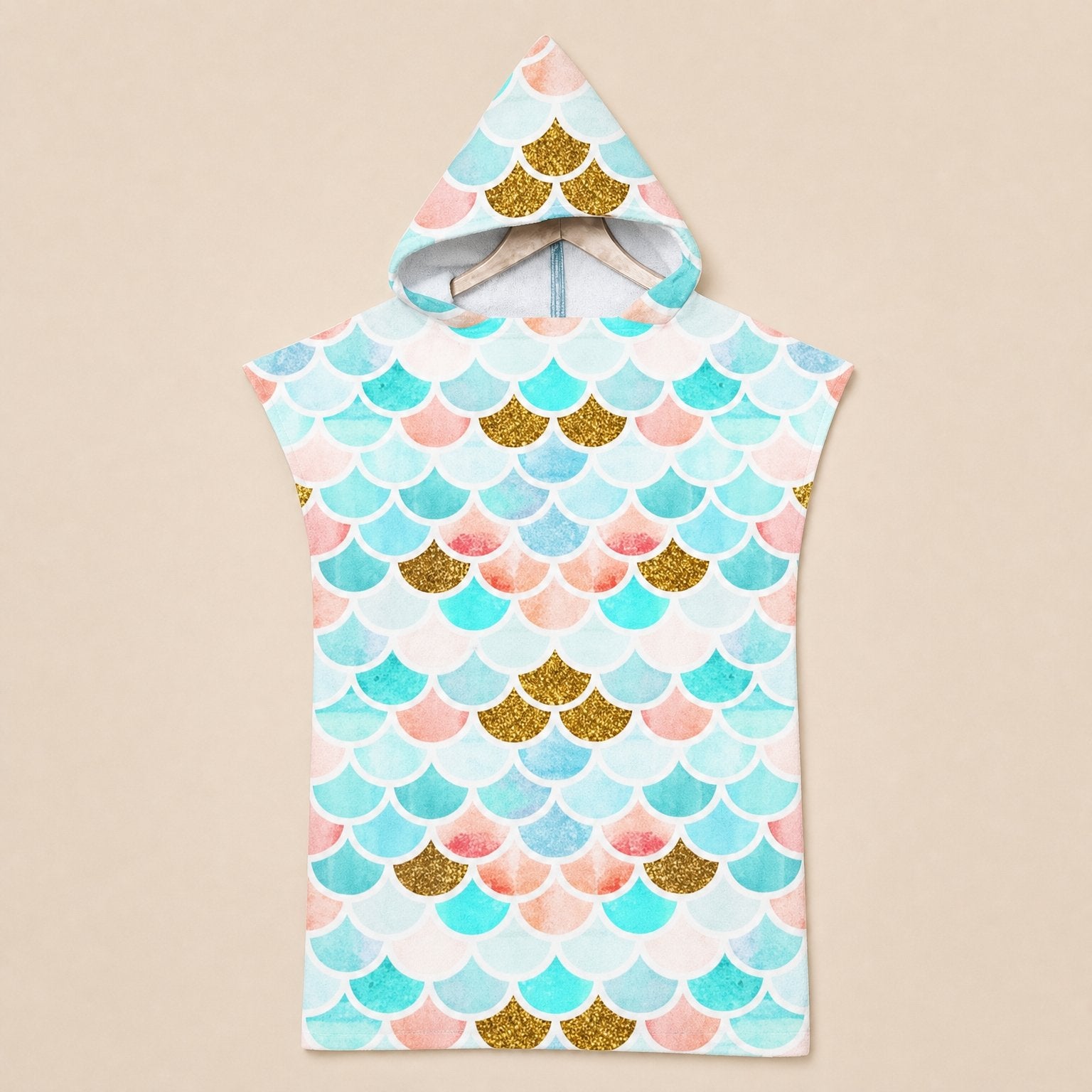 Poncho serviette a capuche motif écailles menthe et corail, présenté sur un cintre, vu de face.