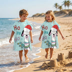 Poncho serviette à capuche motif lama bonnet de Noël, porté par deux enfants marchant côte à côte sur le rivage de la plage.