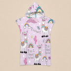 Poncho serviette a capuche motif lamas et arcs-en-ciel, présenté déplié à plat sur un fond clair.