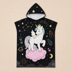 Poncho serviette a capuche motif licorne étoilée, présenté à plat sur un fond uni clair.