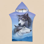 Poncho serviette a capuche motif loups, posé à plat, montrant le design détaillé des deux loups.